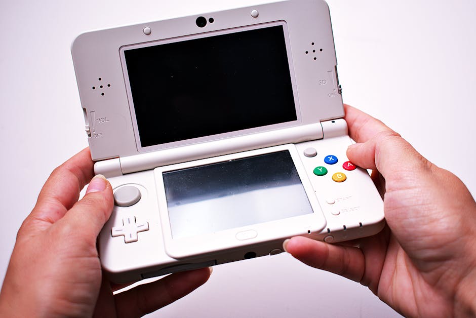Close-up of hands holding a white portable gaming console.